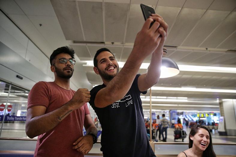 Nas Daily founder and travel vlogger Nuseir Yassin taking a selfie with a fan at Changi Airport Terminal 2