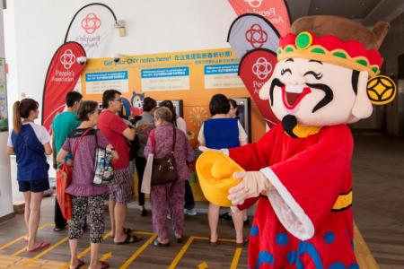 Customers queue up to withdraw new notes from a POSB pop-up ATM. 