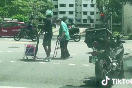 'Really good-hearted' motorcyclist gets off bike to help woman with walker and trolley cross road