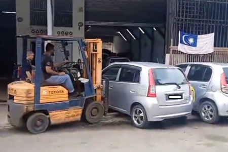 Frustrated owner uses forklift to move cars blocking workshop