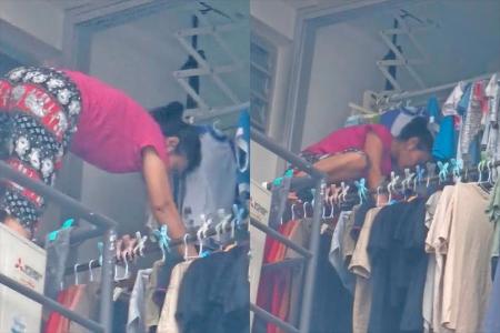 Maid balances on clothes rack outside 18th-storey flat