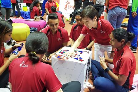 Minister for Culture Community and Youth Grace Fu (kneeling) interacts with able-bodied and para-athletes at the Team Singapore camp at the Singapore Sports Institute in Kallang, before launching the #OneTeamSG Ready for KL campaign.