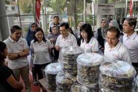 East Coast GRC MPs (from left) Dr Maliki Osman, Ms Cheryl Chan, DPM Heng Swee Keat, Ms Jessica Tan, Mr Tan Kiat How speaking to bakers who made the cookies that were given out to beneficiaries, on April 6.