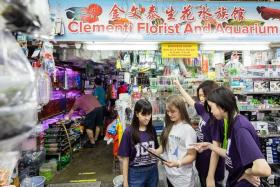 Ngee Ann Polytechnic students (from left) Ashley Goh, Synette Teh, Lau Yixin and Grace Foo using JourneyX, an app they developed which takes users on a walking trail to 15 stops around Clementi.