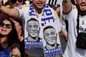 A Real Madrid fan with football scarf depicting French footballer Kylian Mbappe in Madrid on May 12. Mbappe signed for Real on June 3.