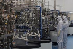 Workers in a lab where the human papillomavirus vaccine is produced at the Serum Institute of India in Pune.