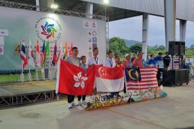 Koh Kwee Boon (fourth from left) and his director Gary Goh (third from left) struck gold in the B2 men&#039;s singles event at the Asia Bowls for the Disabled Championships.