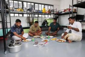 Migrant worker Karthikeyan (right) having lunch with his colleagues at the dormitory during the Deepavali celebrations at Westlite Mandai dorm on Nov 4, 2021.