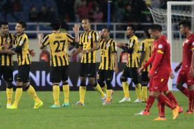 Malaysia&#039;s players celebrate after booking their place at the Suzuki Cup final by beating Vietnam 4-2 in Hanoi.