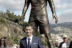 Cristiano Ronaldo and his son pose for a photo in front of a statue erected in the Real Madrid superstar&#039;s home town.