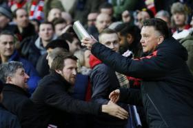 Louis van Gaal hands out presents to Manchester United fans before his side&#039;s EPL clash against Newcastle at Old Trafford on Boxing Day.