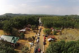 An aerial view of the flooded road in the village of Bonggol Nering. The road leads to the still flooded town of Kusial Baru.