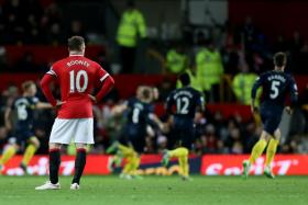 Manchester United&#039;s Wayne Rooney looks on as Southampton players celebrate Dusan Tadic&#039;s goal at Old Trafford.