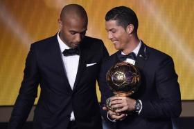 Cristiano Ronaldo receives the Ballon d&#039;Or trophy from Thierry Henry.