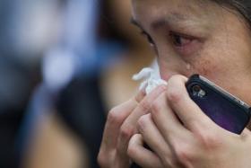  A Singaporean cries as she reads condolence messages at the entrance to the Istana following the death of former prime minister Mr Lee Kuan Yew in Singapore on March 23,