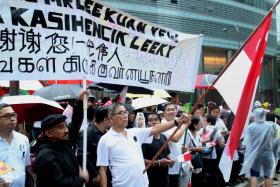 Mr Soh Swan Fong holds the Singapore flag aloft in in front of banners he and his friends prepared to pay their final respects to Mr Lee Kuan Yew.