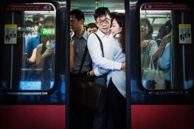 Photographer Edwin Koo took to capturing raw moments of commuters in the MRT. 