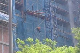 SCDF officers retrieving a body on Friday morning (April 17) from a crane at a construction site at Queen Street.

