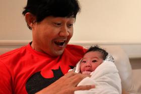 Chen Tianwen holding his new born baby boy. 