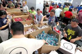 PICK A PACK: Ms Chen (in green) working as part of a production line for the packing of fun packs.