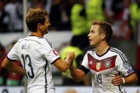 Thomas Mueller (left) celebrates with Mario Goetze during their Euro 2016 qualification match against Poland in Frankfurt, Germany, September 4, 2015. 