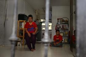 VICTIM: Madam Jurina with one of her two sons, Mr Muhammad Shahirul Junadi, who is autistic, in their one-room rental flat.