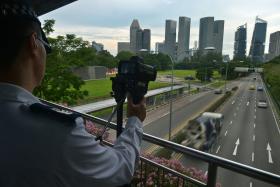 NEW: A traffic police officer uses the latest speed camera on the bridge along Nicoll Highway to track vehicles violating the speed limit. 