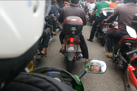 Ngee Ann Polytechnics student Muhammad Fareez Buhari (reflected in the motorcycle mirror) has to endure the long wait on the causeway to travel back to his home in Johor Baru to break fast.