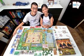 Ms Christina Ng (right) and Mr Yeo Keng Leong (left) with the three-player board game they designed, Three Kingdoms Redux.