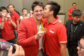 Singapore&#039;s Olympic gold medallist Joseph Schooling gets a kiss from his buddy Teo Zhen Ren at Changi Airport on 15 August 2016. 