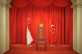 The Presidential Chair flanked by the State Flag and the Presidential Flag in the Istana.