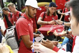 Pierre-Emerick Aubameyang (front) and Hector Bellerin (background) obliging autograph hunters after arriving at the Shangri-La Hotel on Monday morning. 