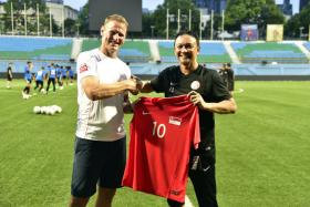 Teddy Sheringham (left) receiving a Singapore shirt from Young Lions coach Fandi Ahmad during a training session at the Jalan Besar Stadium on Thursday.