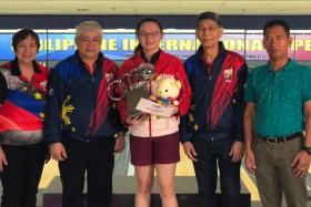 Singapore bowler Amabel Chua (centre) posing with the trophy and officials at the Philippine International Open Tenpin Bowling Championships.