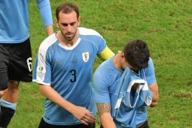 Luis Suarez (right) being consoled by captain Diego Godin.