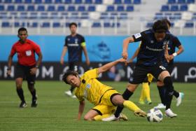  Tampines midfielder Kyoga Nakamura (in yellow) vying for the ball with Gamba Osaka’s Kosuke Onose.