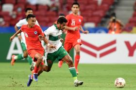 Singapore&#039;s Faris Ramli (left) fights for the ball with Indonesia&#039;s Ricky Richardo Kambuaya during the first leg of the semi-finals on Dec 22, 2021.