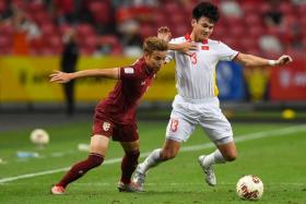 Thailand&#039;s Theerathon Bunmathan (left) fights for the ball with Vietnam&#039;s Ho Tan Tai during the AFF Suzuki Cup 2020 semi-final match on Dec 26, 2021.