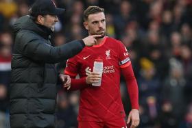 Klopp (left) talks to Liverpool midfielder and club captain Jordan Henderson. 
