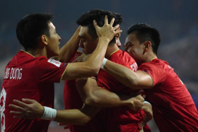 Vietnam's Nguyen Tien Linh celebrates with teammates after scoring against Indonesia. 
