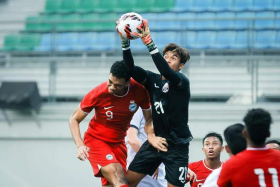 Singapore’s Jordan Emaviwe (left) challenging for the ball with Cambodia goalkeeper Reth Lyheng. ST PHOTO: GAVIN FOO
