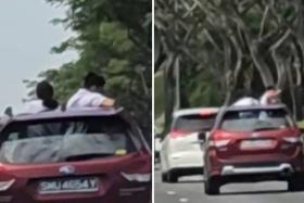 2 students stand in moving car through moonroof on KPE