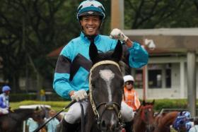 Jockey Darren Danis punching the air in delight as he brings to scale his first Singapore winner, $116 long shot Run Buddy Run, at Kranji on June 22.
