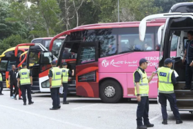 Malaysia&#039;s enforcement officers inspecting tour buses and vans in Gombak, Selangor, on July 2. 
