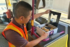 Bus captain Chen ShaoXi viewing the automated external defibrillator on bus 138.