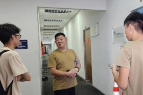 Mr Huang (centre) was among the 50 drivers who showed up at the centre to collect their VEPs.