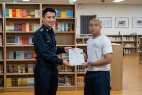 Inmate ‘Nabil’ (not his real name) receiving his O-Level results from SUPT Luke Leong, Superintendent of Institution Tanah Merah 1 &amp; 2.