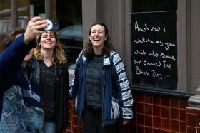 Fans of Taylor Swift take images next to lyrics from the song The Black Dog by Taylor Swift, written outside The Black Dog pub.