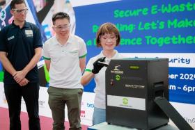 Senior Minister of State Amy Khor using a hard drive degausser that erases data at the Westgate mall event on Oct 13. With her were Alba&#039;s Mr Jakob Lambsdorff (far left) and National Environment Agency CEO Wong Kang Jet.