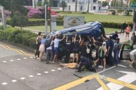 A photo circulating on social media shows about a dozen people lifting a blue Honda while others tended to the injured.